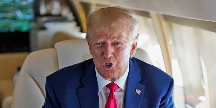 Donald Trump speaks to staff while flying from Georgia to North Carolina to speak at the North state's Republican Party's convention on June 10, 2023. 